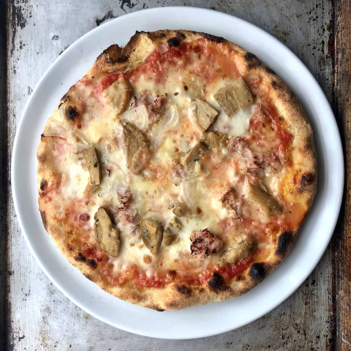 Fully baked porcini mushroom prosciutto cotto and onion pizza on a thin crust Caputo Nuvola 00 flour pizza dough.
