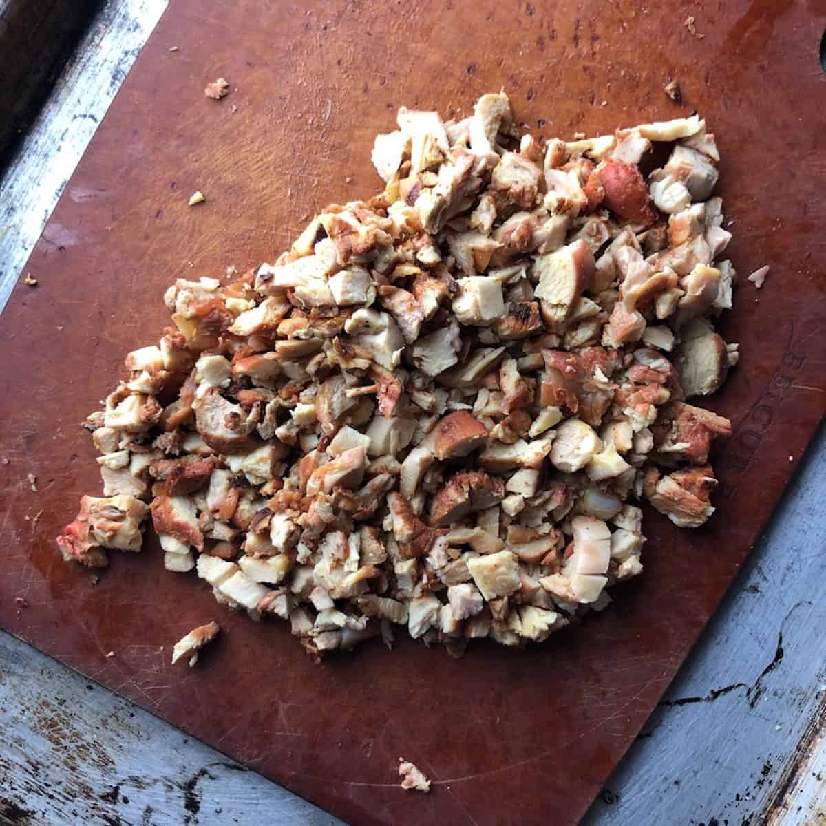 Finely diced pollo asado al carbon on an Epicurean cutting board ready for enchiladas, taquitos, and flautas.
