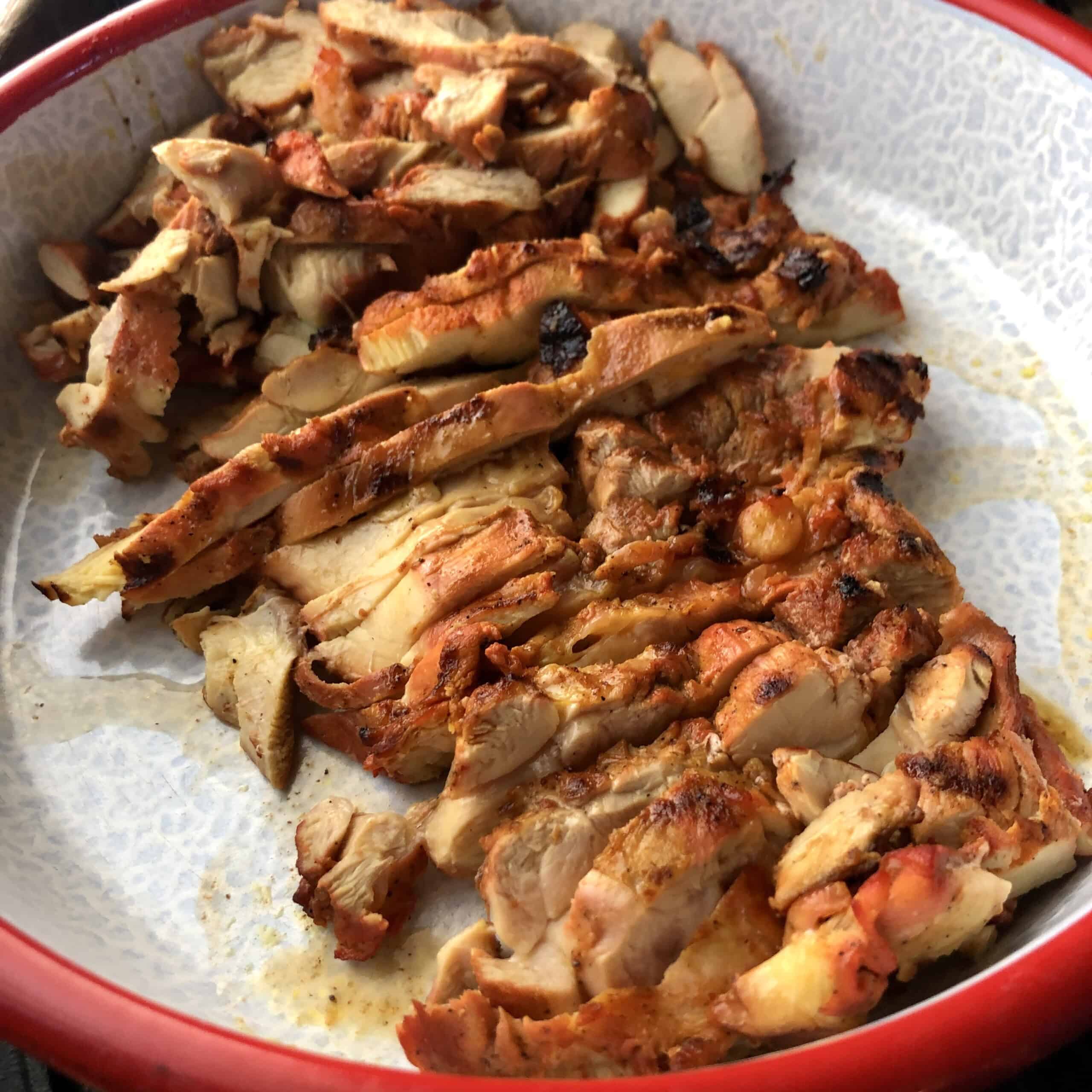 Grilled sliced pollo asado in a serving platter ready to be used for enchiladas, quesadillas, tortilla soup, fajitas, and more.
