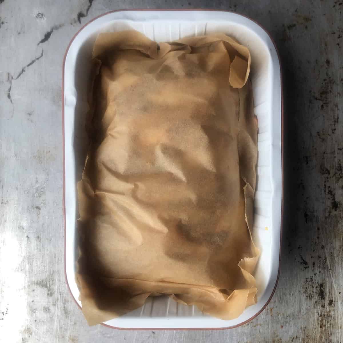 Parchment paper covering sliced pollo asado ready to wrap and refrigerate or freeze for meal prep.
