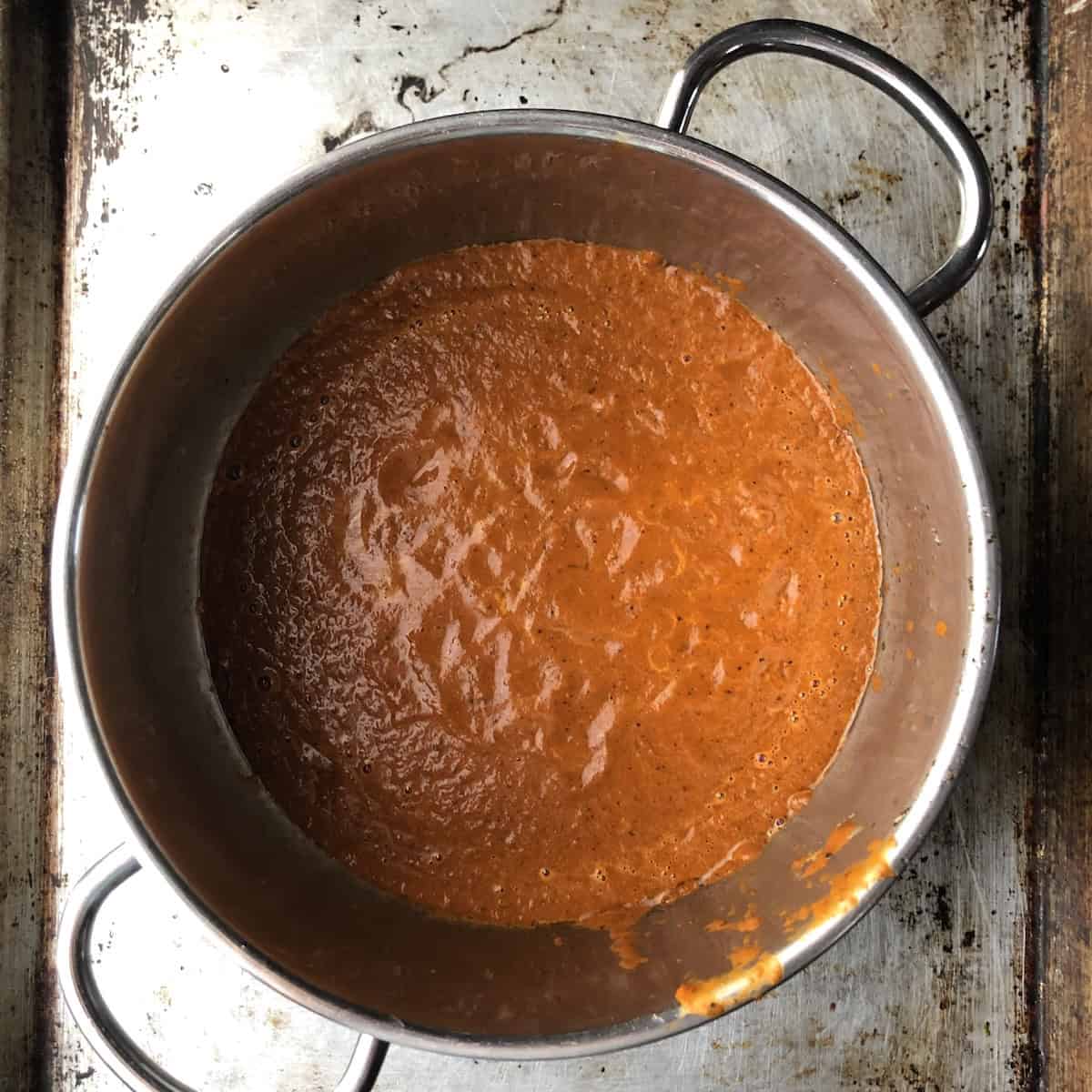 Tomato and chile puree added to a saucepan to saute for an authentic mexican tortilla soup recipe.
