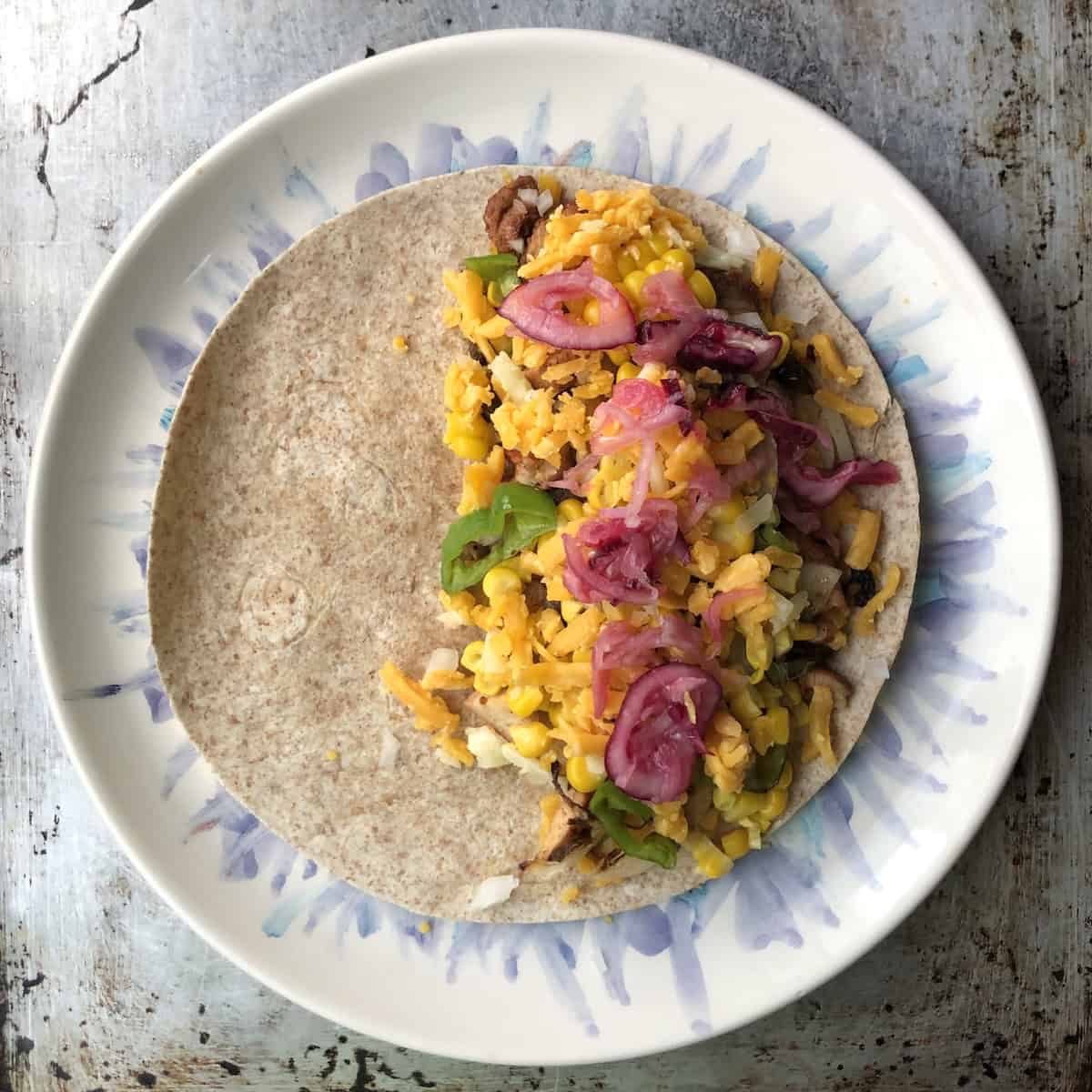 Hot pink quick pickled shallots pickled with lime juice and salt added as a bright chicken quesadilla seasoning layer.
