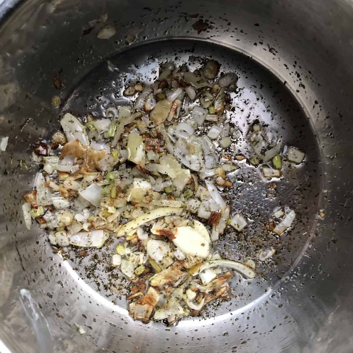 Golden brown aromatics including onions, garlic, and epazote ready to be added to the blender with the tomatoes and chiles.
