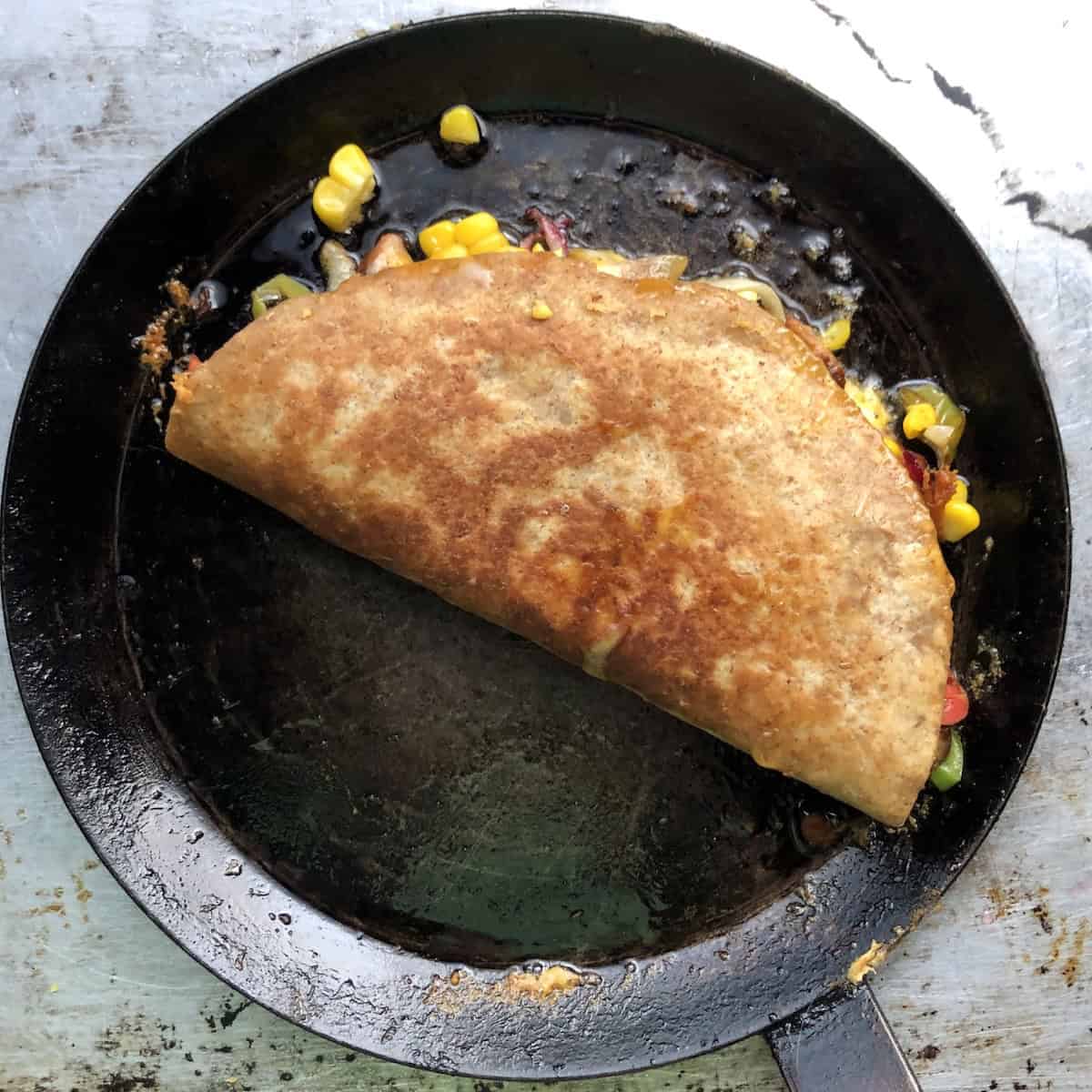 A fully cooked golden brown crispy chicken quesadilla ready to slice, easy quesadilla recipe with pollo asado.
