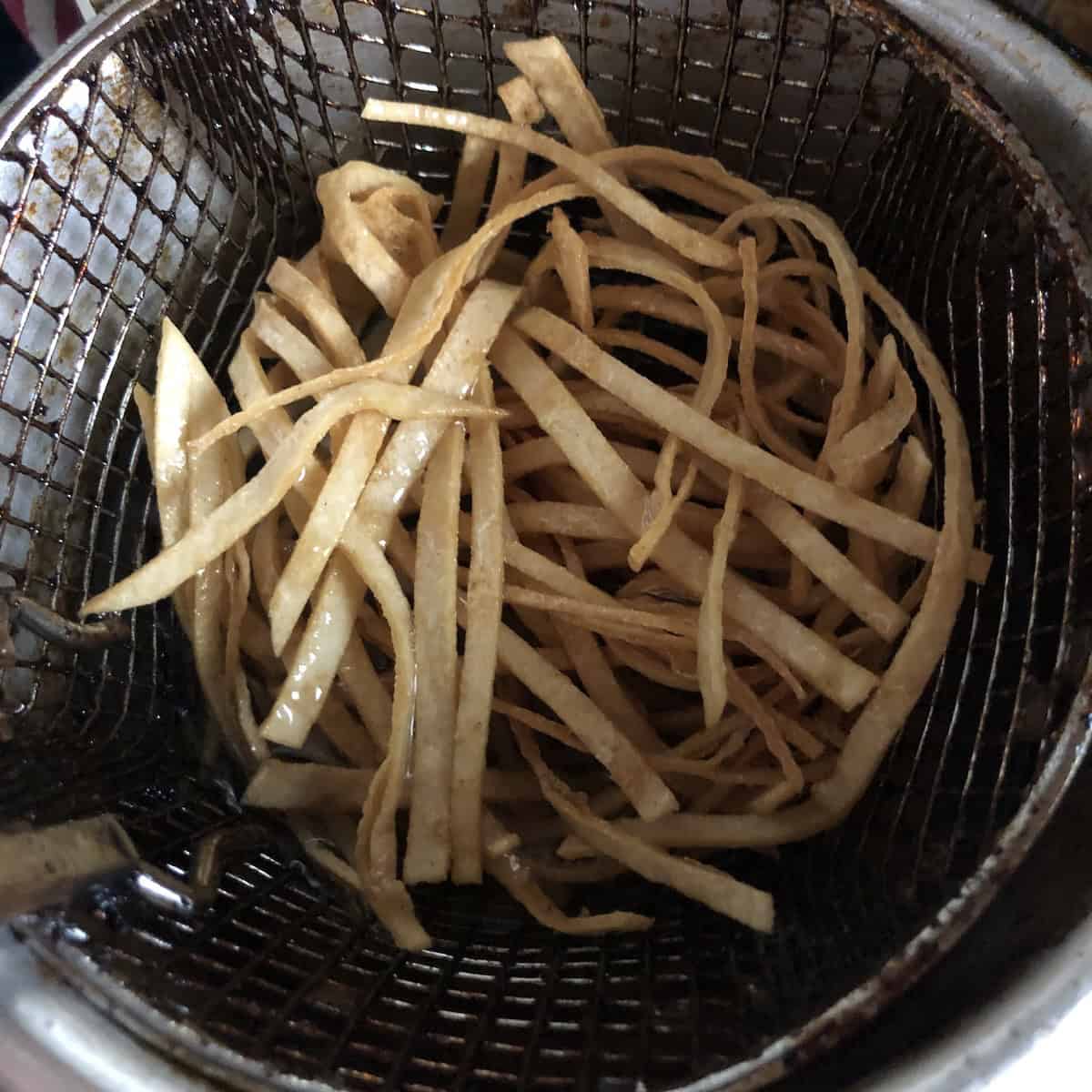 Tortilla strips frying in oil for tortilla soup.
