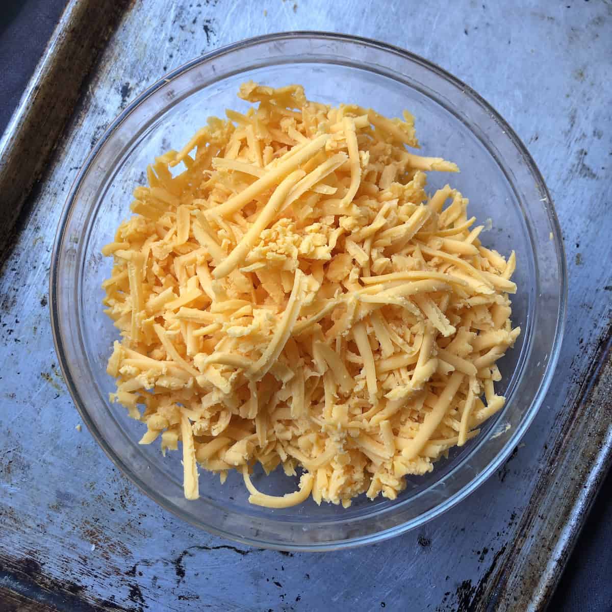 A bowl of freshly grated medium cheddar cheese for chicken quesadillas.