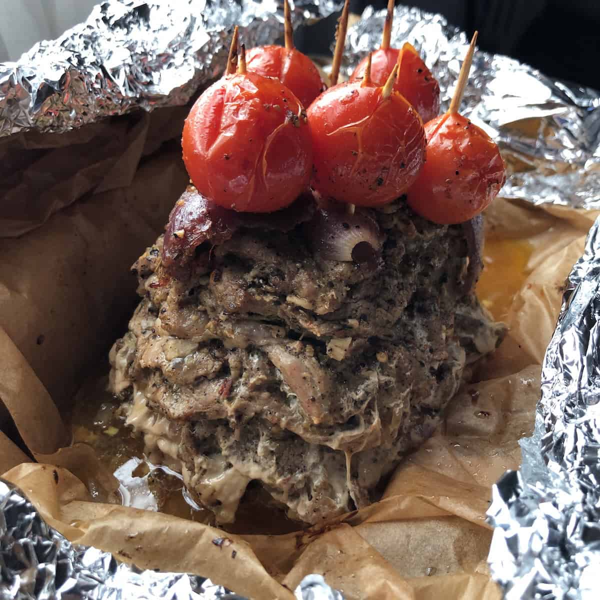 Gyro wrap pork meat tower unwrapped from foil and parchment after two and a half hours of baking about to be quickly basted with its own juices.